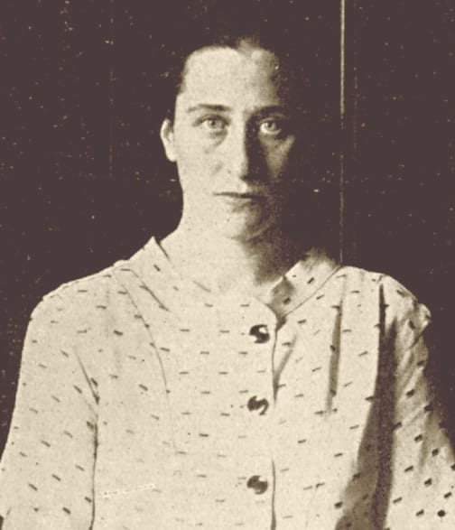 Retrato de mulher jovem, de cabelos presos e blusa clara com botões, em fotografia de revista.